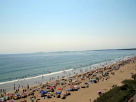 Families enjoying a sunny day at Praia do Forte, with colorful umbrellas and clear blue skies.