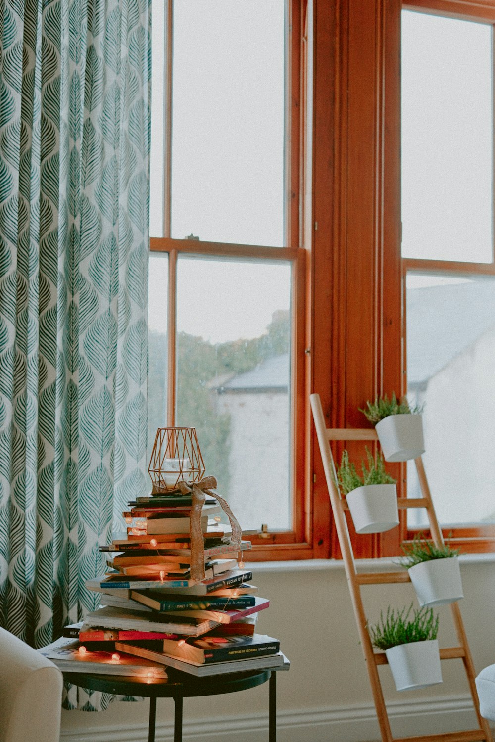 books on table beside potted plants