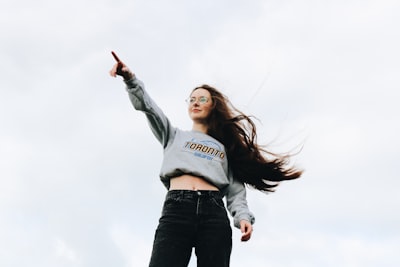 woman pointing using her right hand powerful teams background