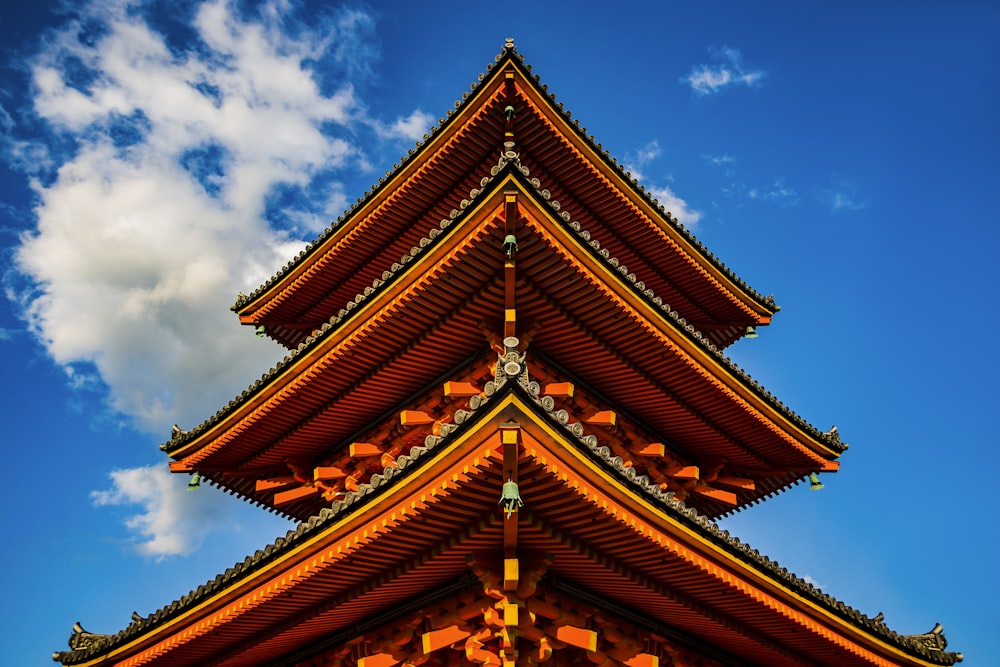 Orangefarbener Turm unter weißem und blauem Himmel