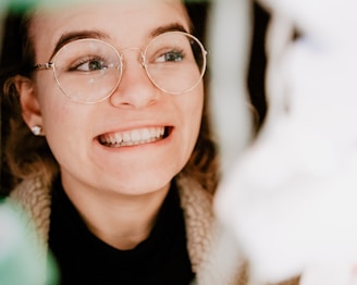 A smiling person wearing natural-looking artificial eyes.