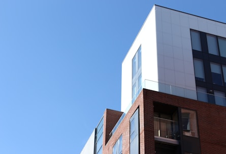 A modern hospital building exterior with a clear blue sky.