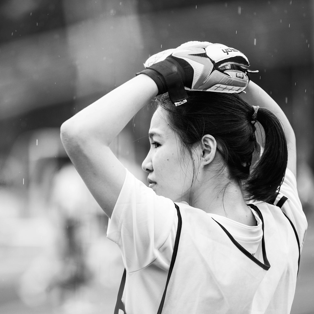 grayscale photography of woman wearing baseball mitt