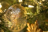 Delicate quilted Christmas ornament hanging on a tree, stitching details visible.