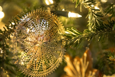 Delicate quilted Christmas ornament hanging on a tree, stitching details visible.