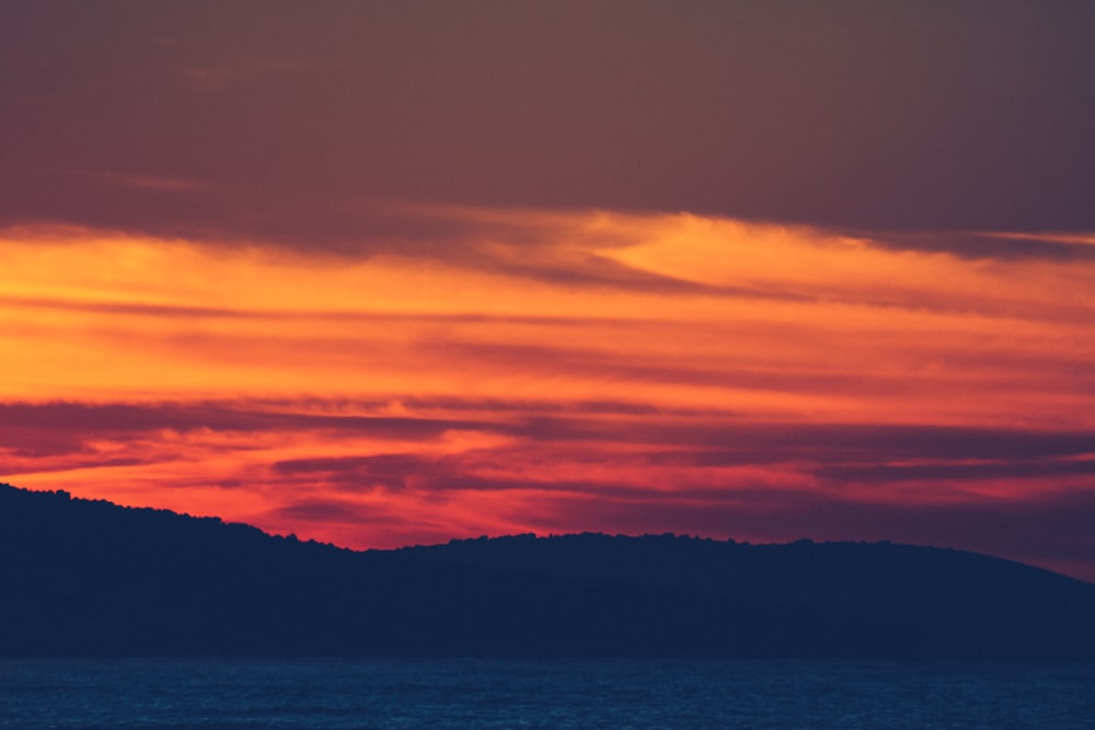 silhouette of mountains near body of water