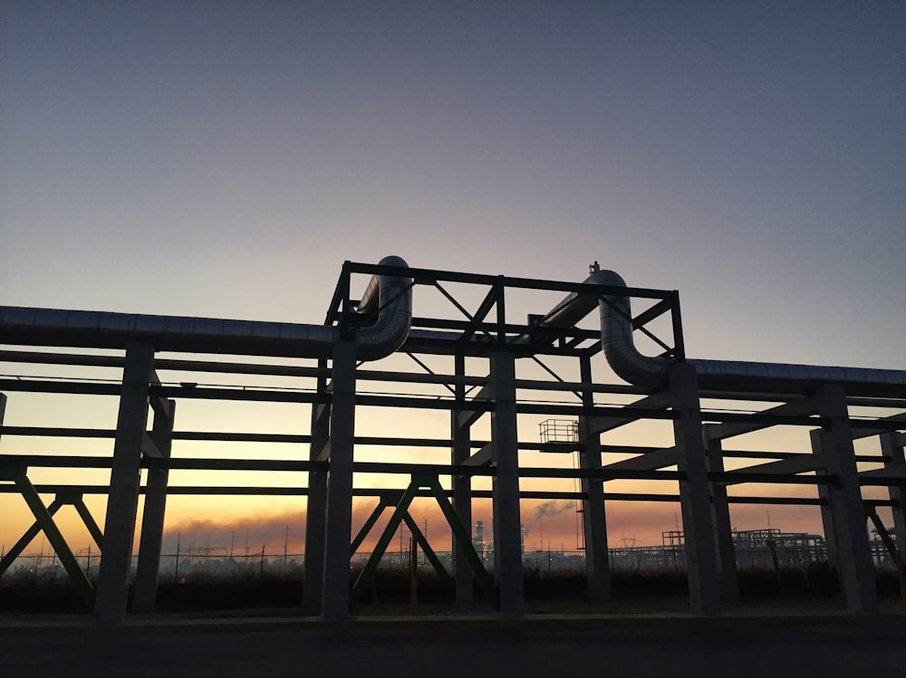 gray metal pipe under blue and orange sky during golden hour