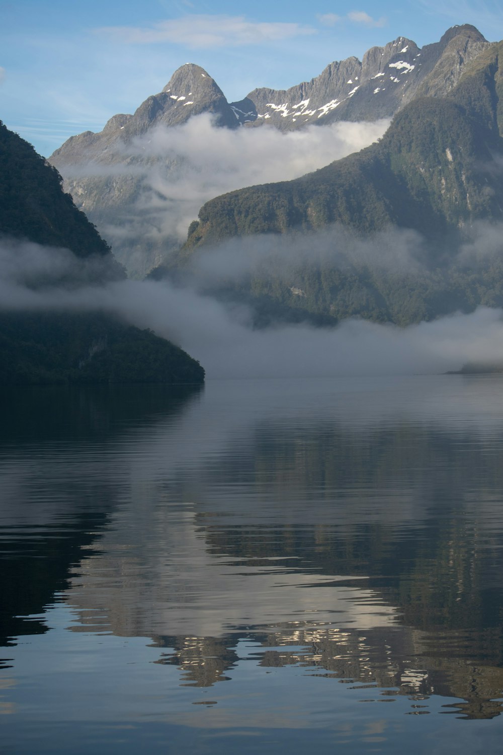 lake beside mountain during daytime