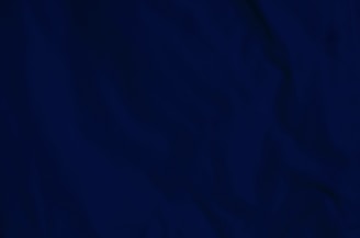 A monochrome close-up of textured charcoal fabric, symbolizing quiet luxury and tactile richness.