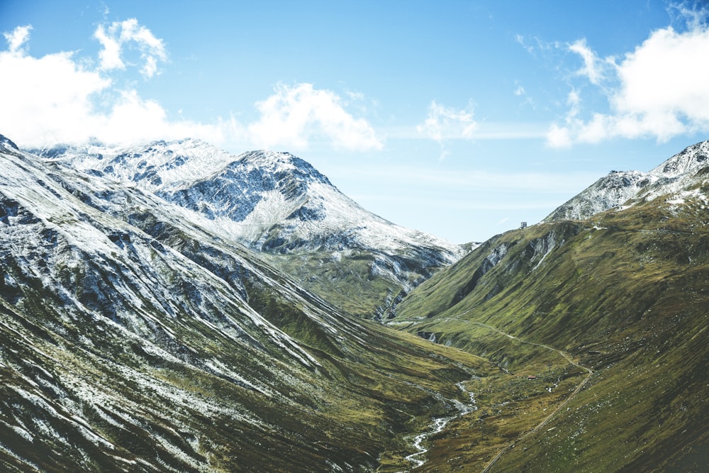 montagne verte pendant le ciel nuageux blanc