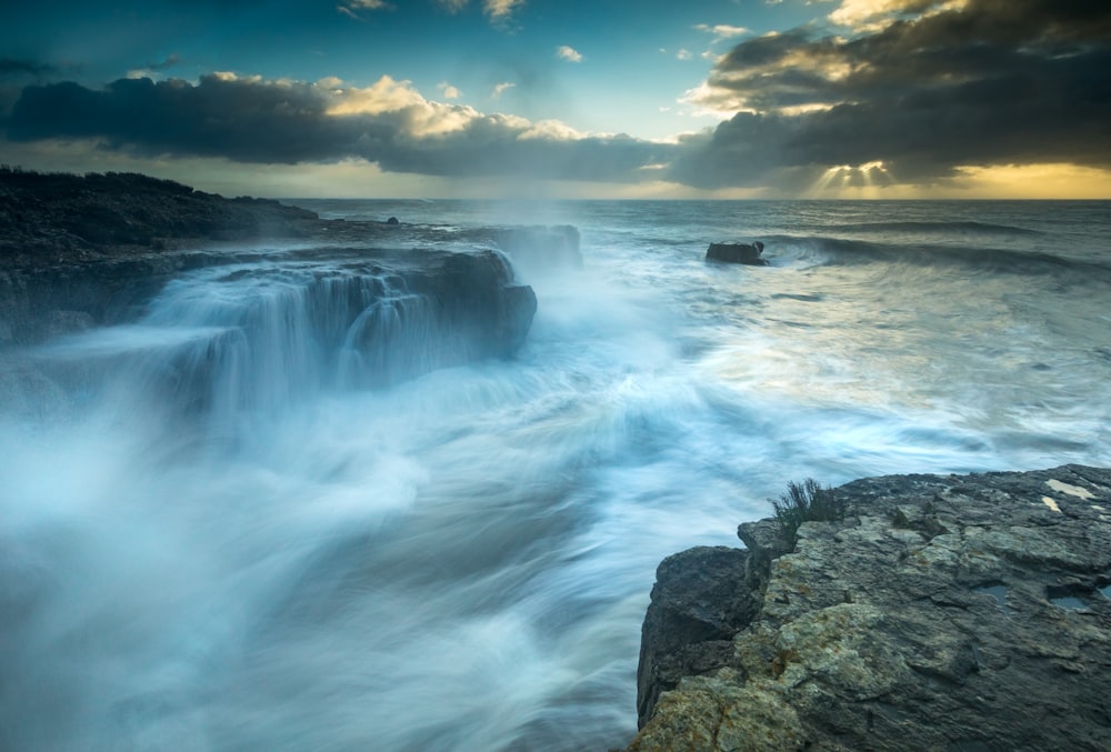 waterfalls under white clouds during daytime