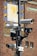 Several surveillance cameras are mounted on a metal pole, with a detailed background featuring a decorative brick wall and a large clock or sundial with a sun motif.