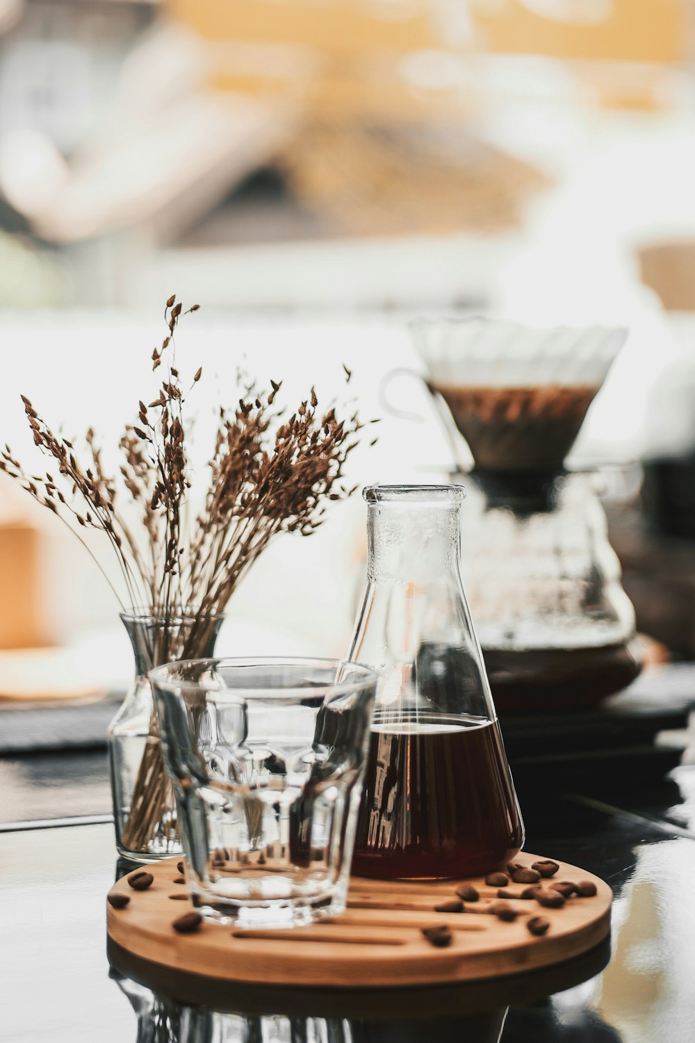 drinking glass beside glass flask and vase