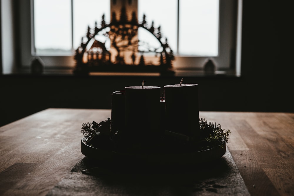 four black pillar candles on top of table