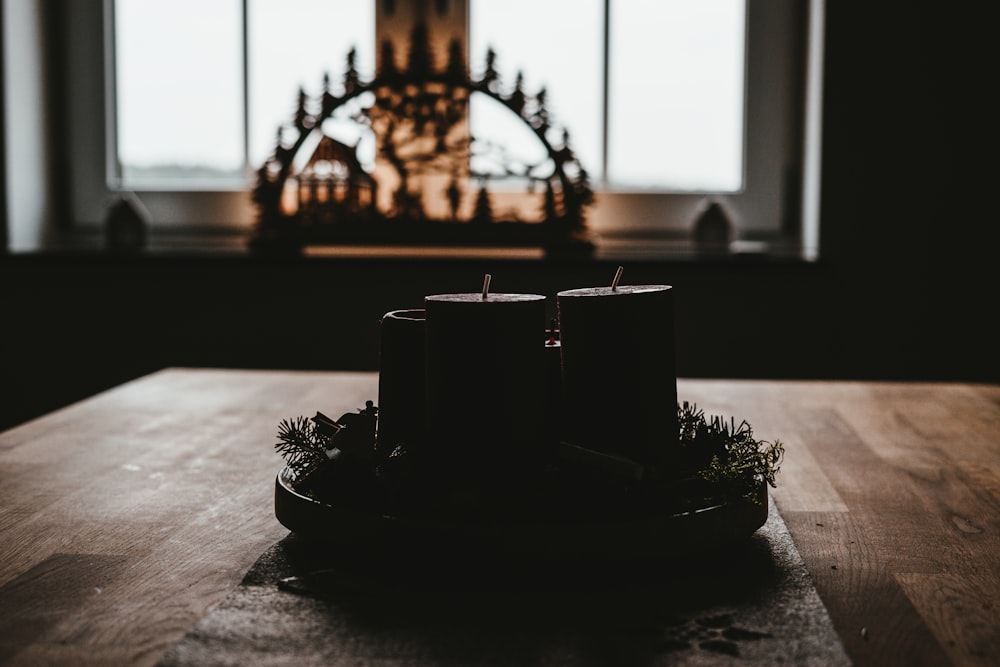 quatre bougies piliers noires sur le dessus de la table