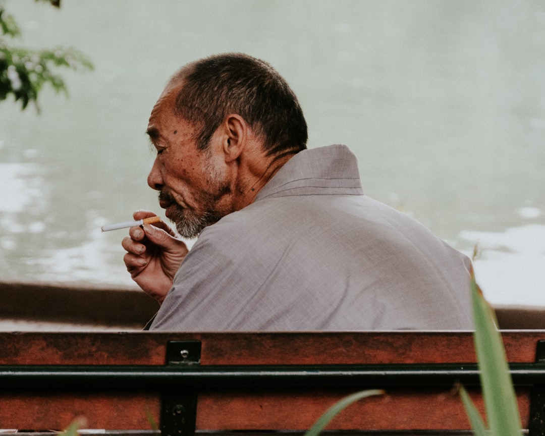 man using red cigarette