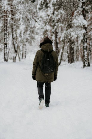 person walking along snow-covered field