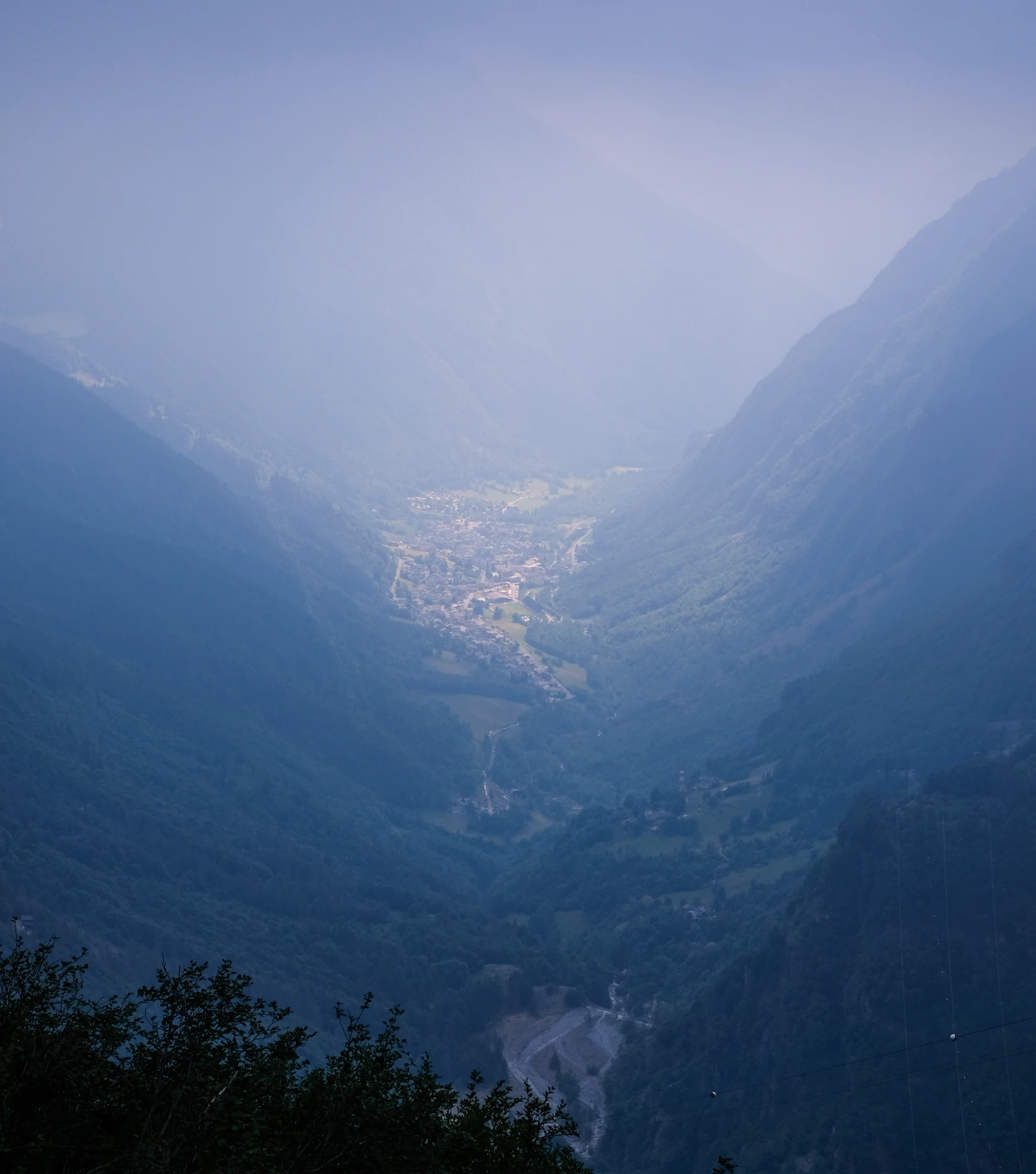 Valle entre montañas envuelto en niebla, tonos suaves y difusos
