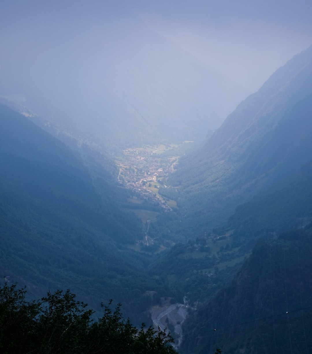 view of valley in between mountains during foggy weather