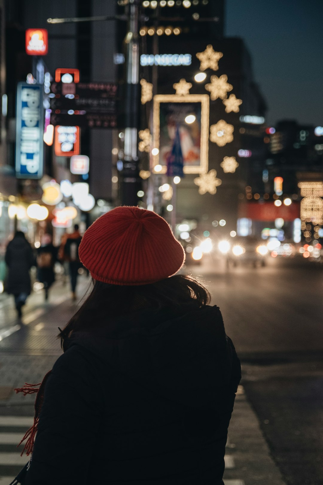 woman standing on pedestrian lane at night