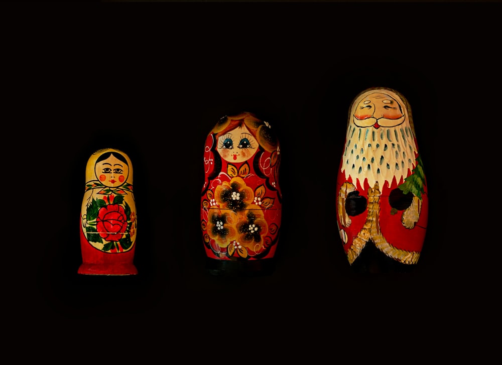 three assorted-color nesting dolls