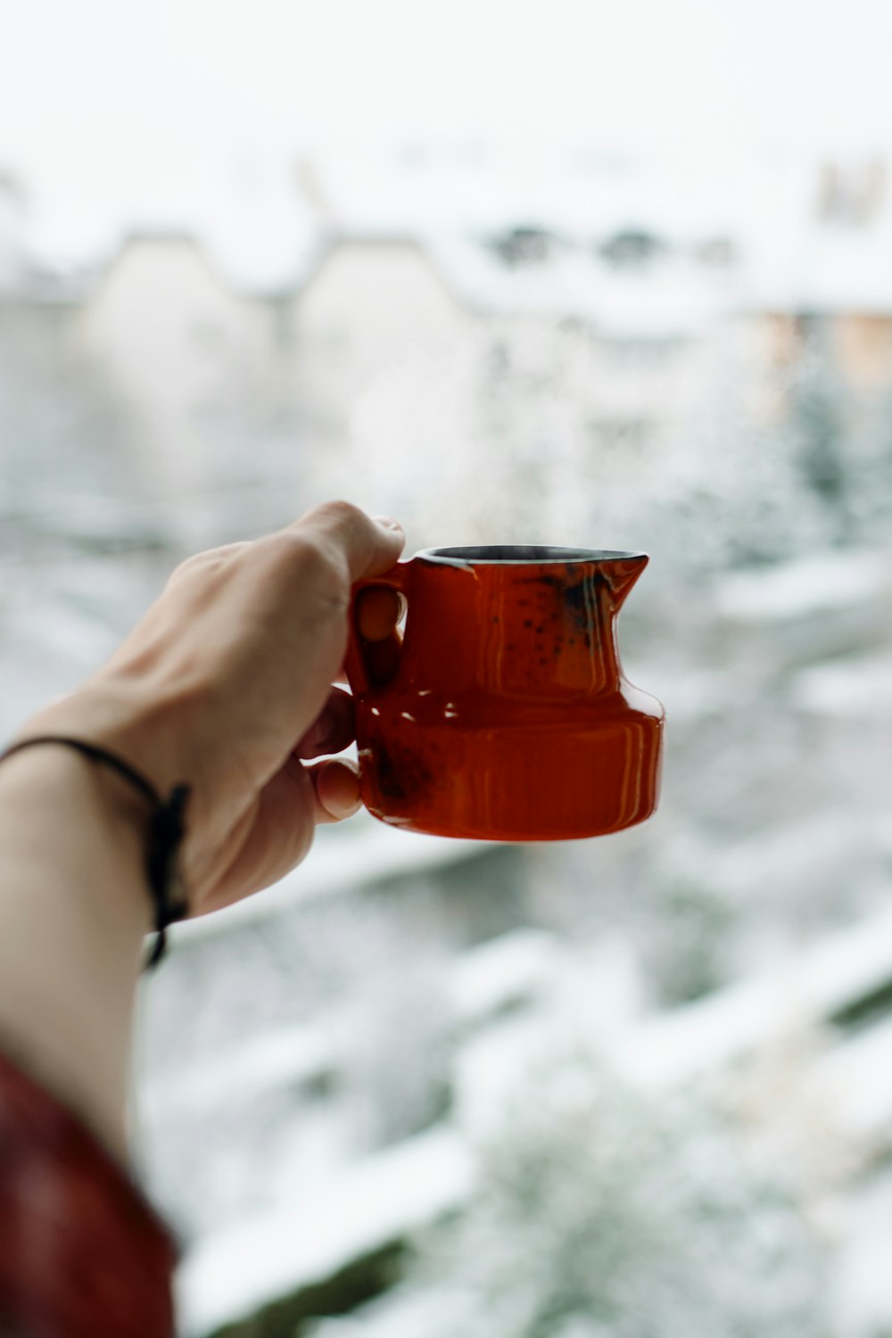 person holding brown mug