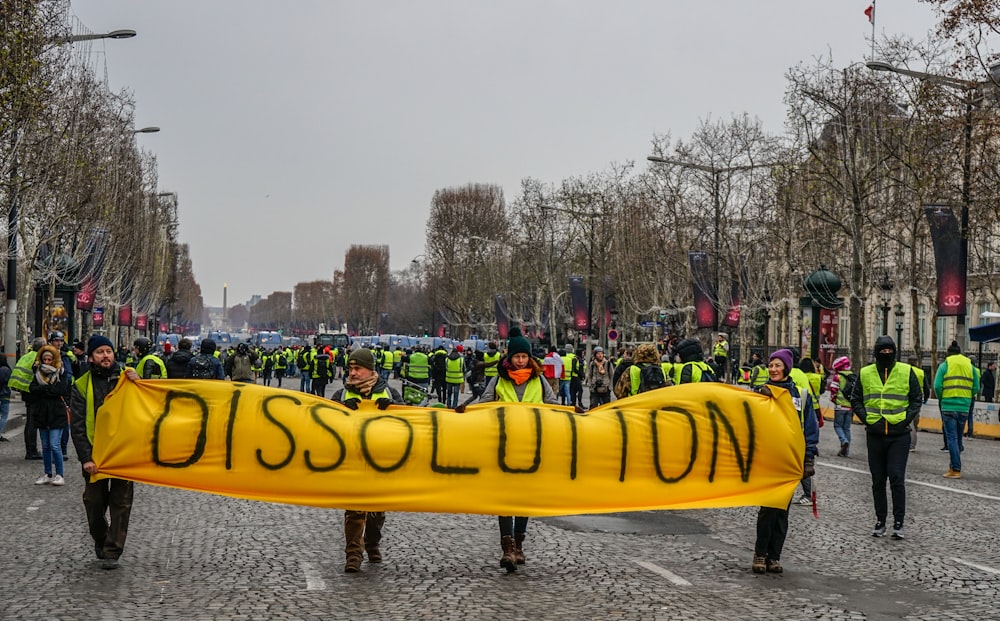 people on rally wearing safety vests holding dissolution banner