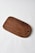 A wooden cutting board with a smooth finish and rounded edges lies on a plain white surface. The wood grain and rich brown color are prominent, with a circular hole near one end.