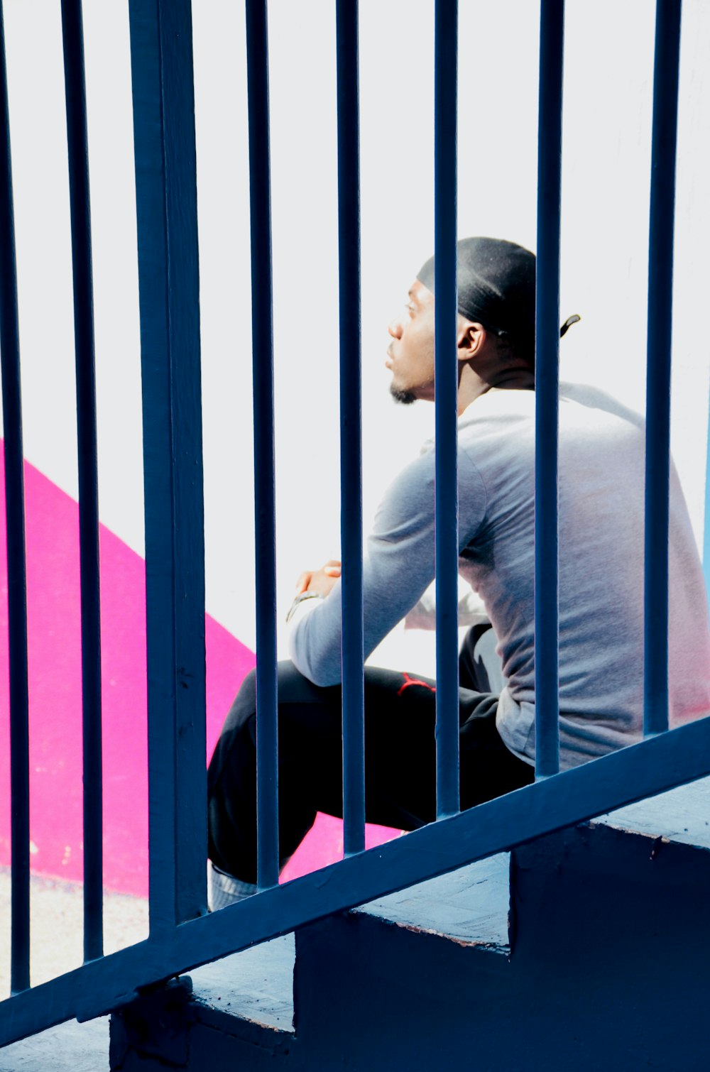 man sitting on stairs near wall during day