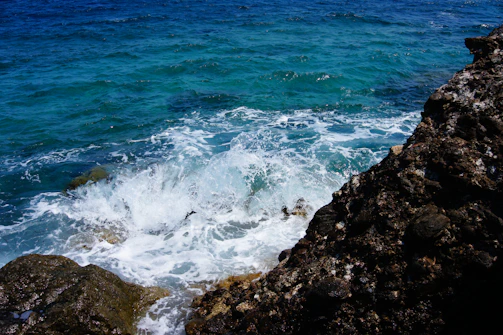 Turquoise waters crashing against rocky shores.
