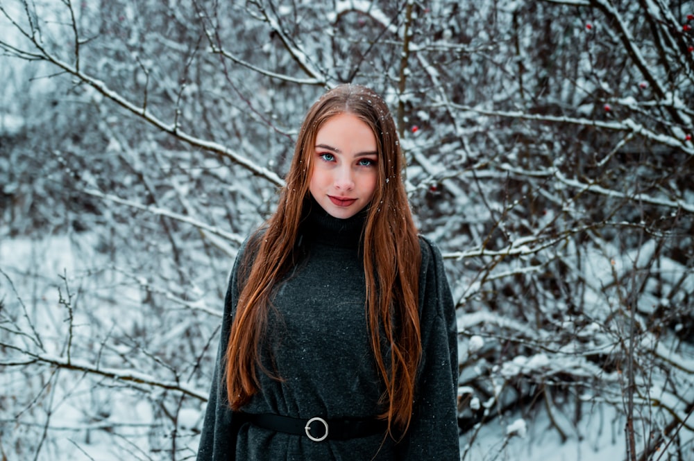 woman wearing black turtleneck coat standing near bare tree