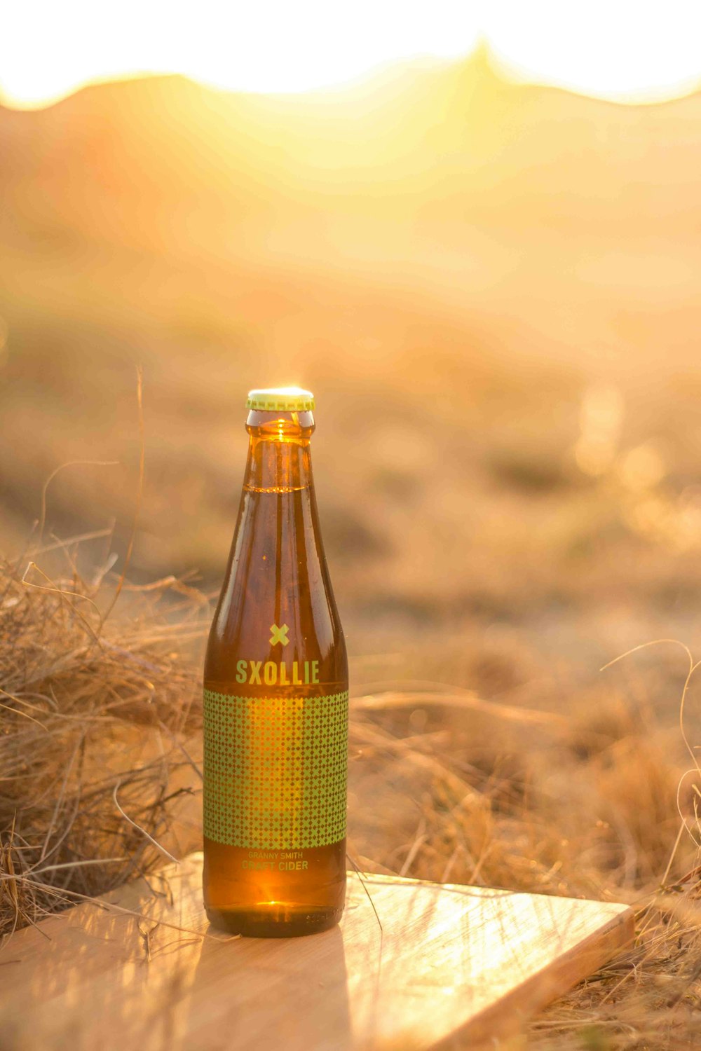 green labeled bottle on brown wooden panel