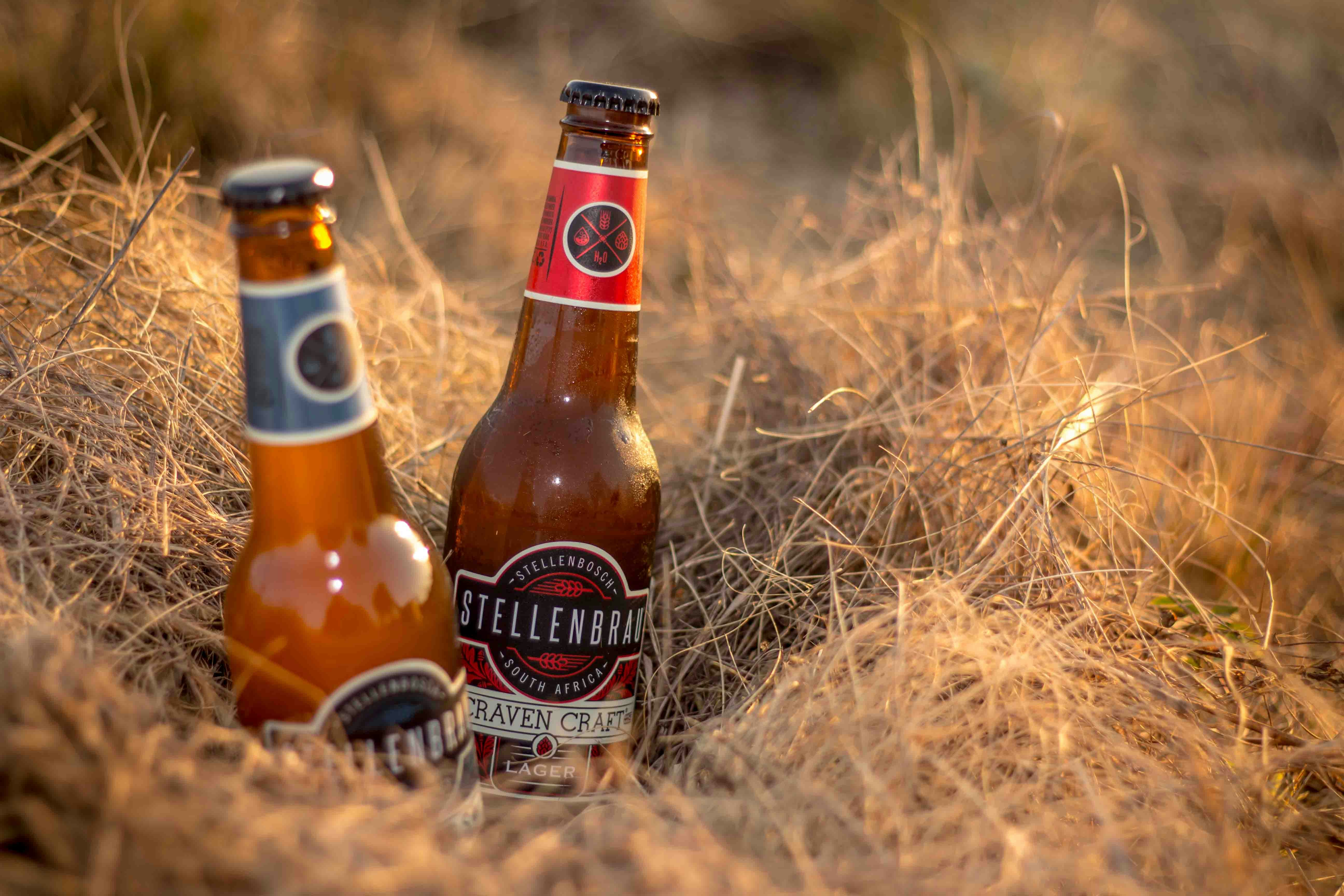two brown glass bottles on brown hays