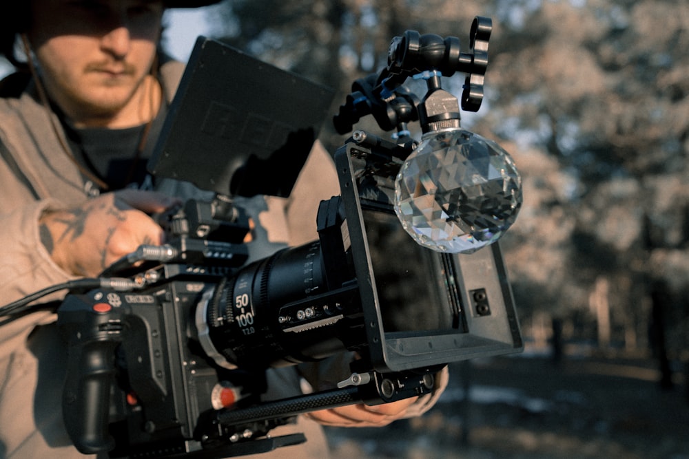 man carrying black professional video camera