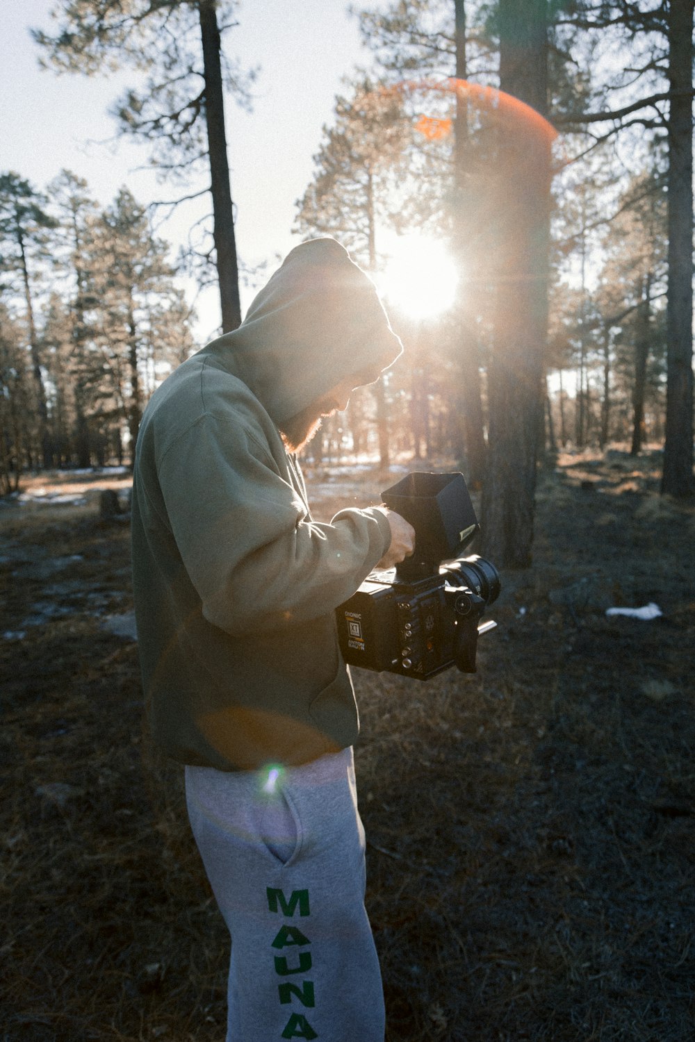 man in hoodie holds black camera