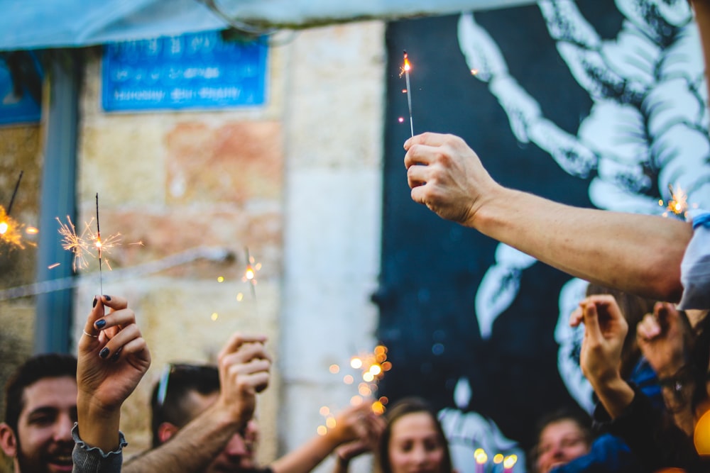 people holding firecracker sticks