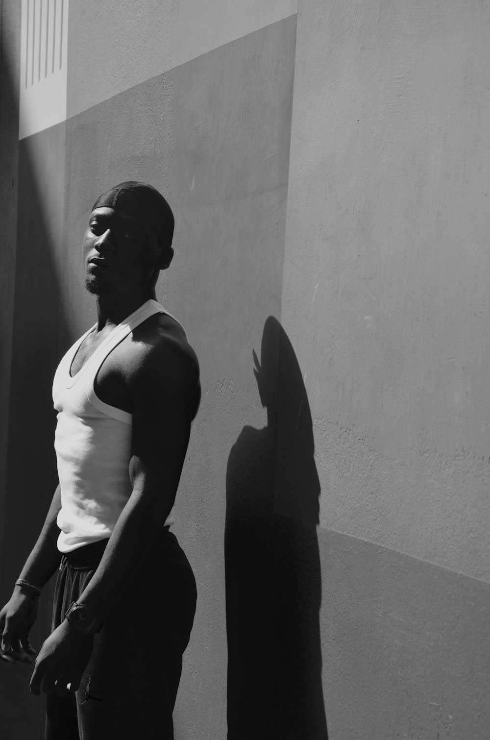 grayscale photography of man standing near wall