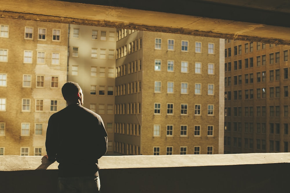 silhouette photo of man in front of buildings