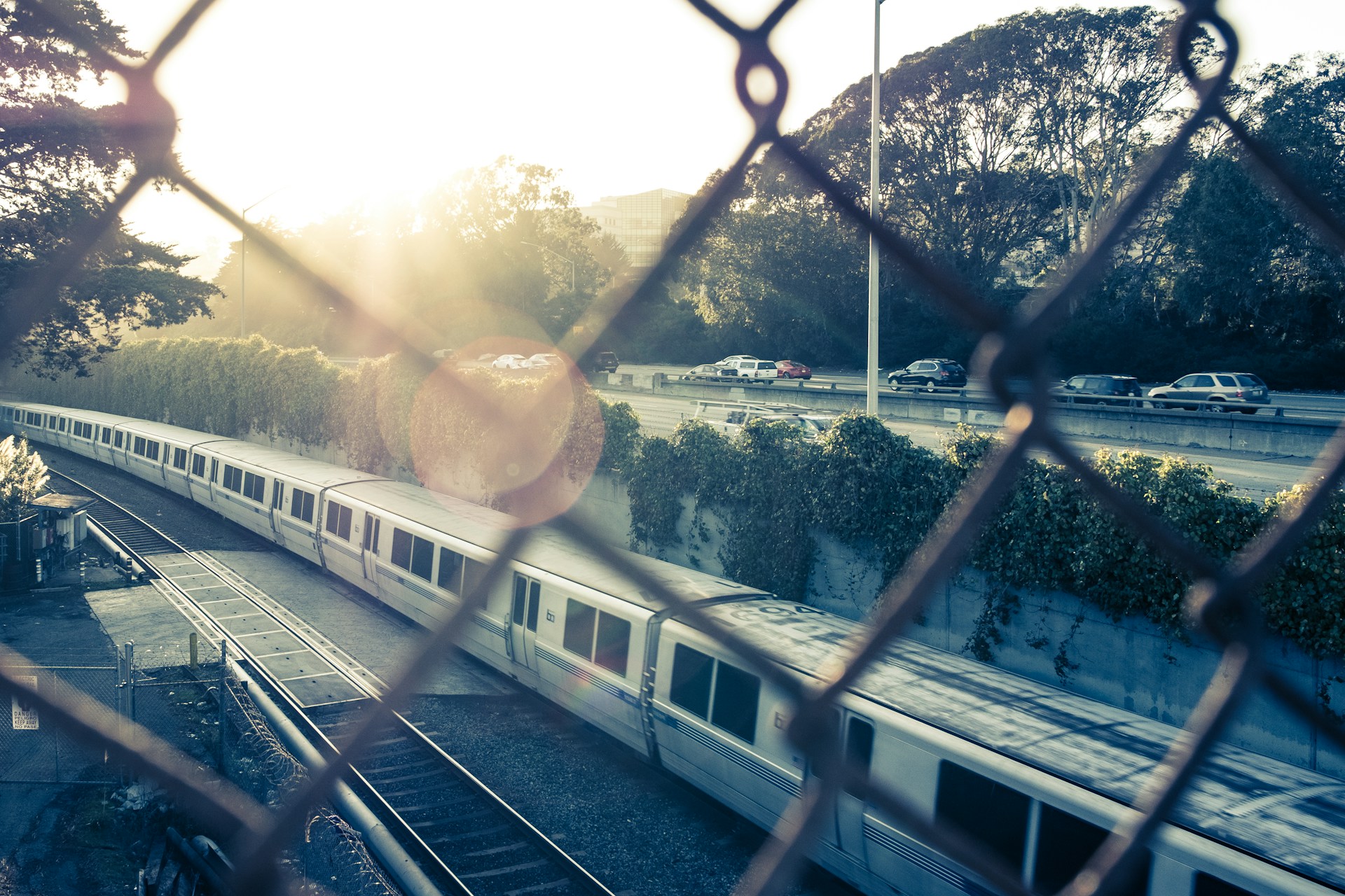 view of train on track from chain link fence during daytime
