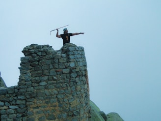 A wise leader figure holding a staff, standing strong amidst ancient stone ruins.