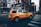 A taxi driving through a busy city street during the day.