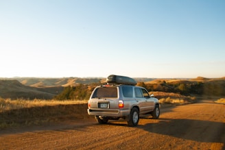 A family happily loading their rental car at a sunny roadside rest stop.