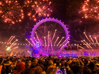pink ferries wheel with fireworks during night time