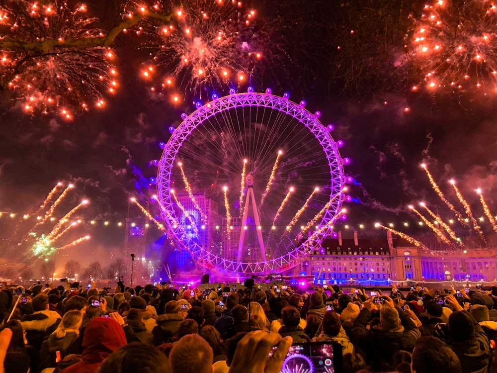 pink ferries wheel with fireworks during night time