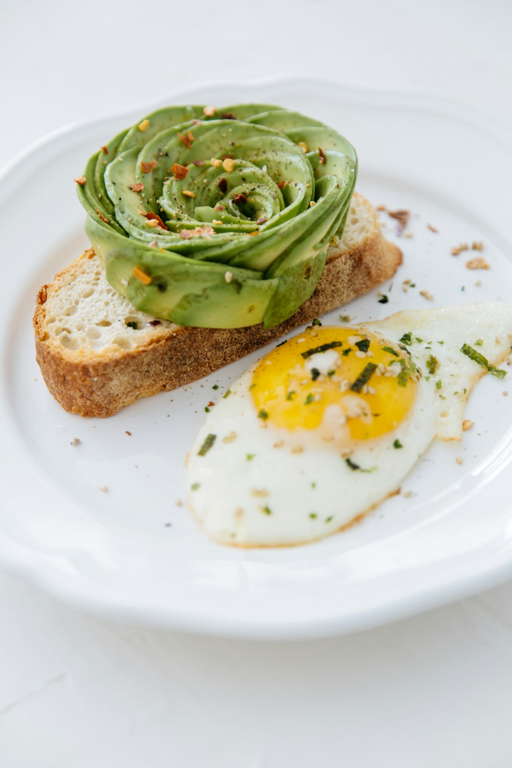 bread with sunny side-up egg on white plate