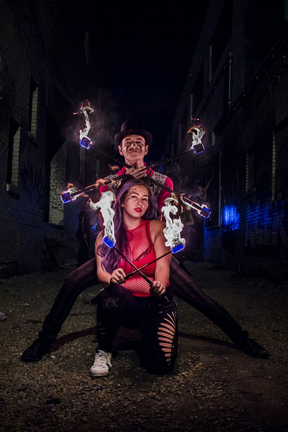woman and man holding stick with fire during night time