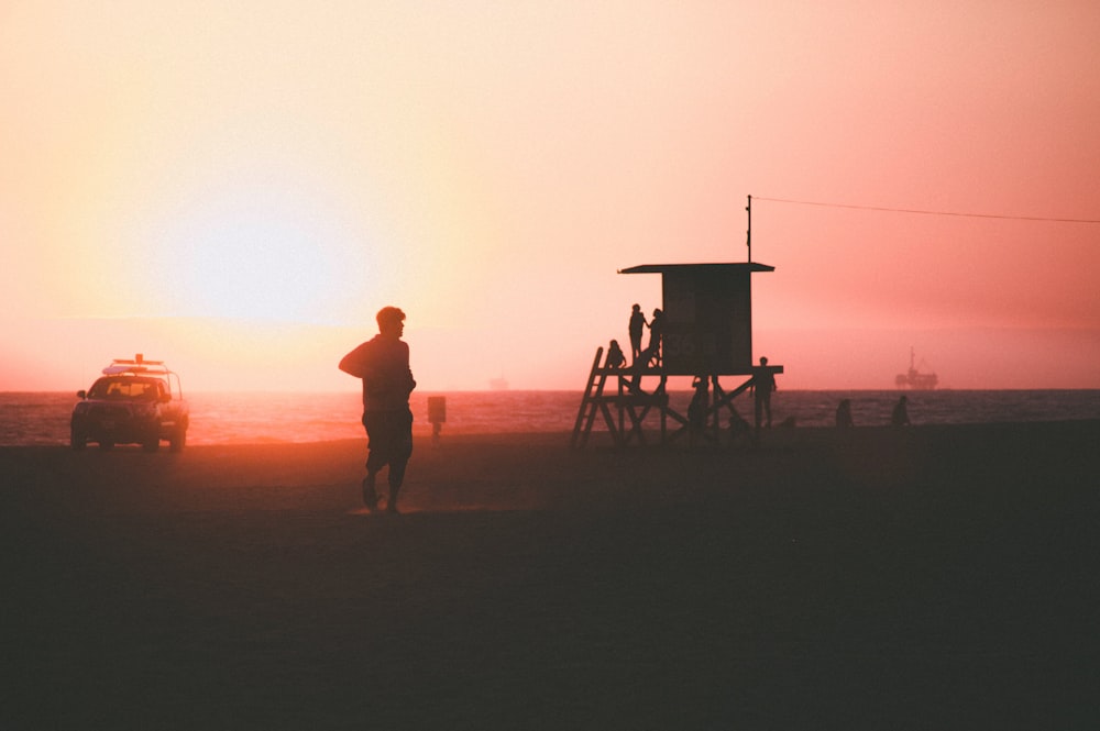 silhouette of person near car and beach