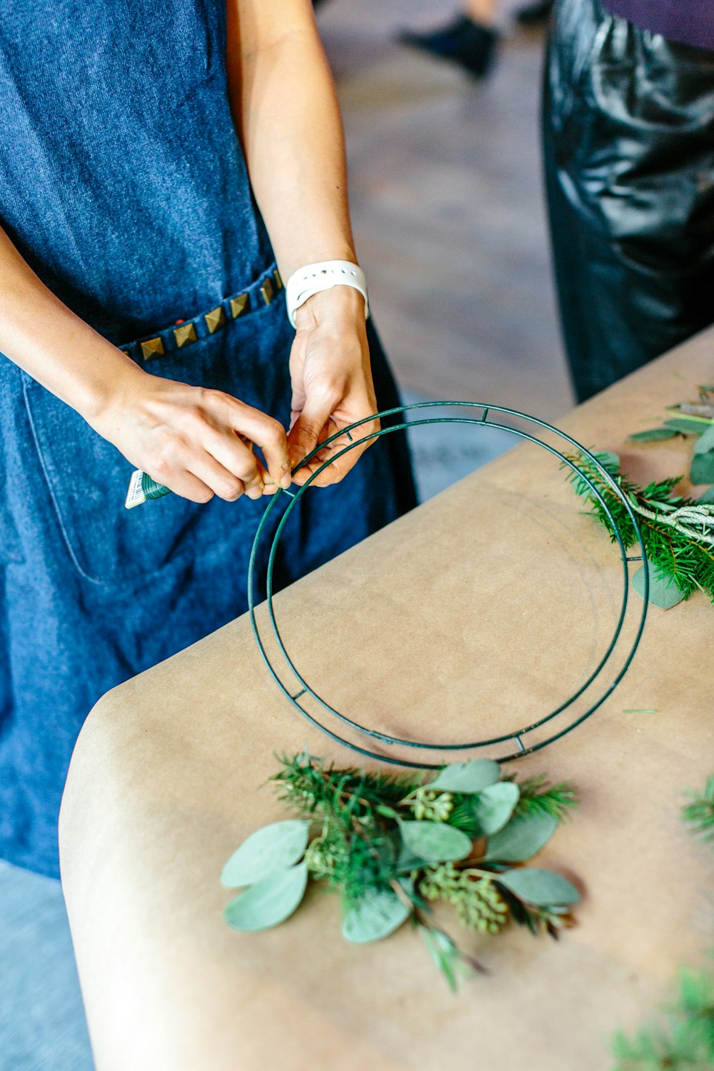 person standing near table holding green stick