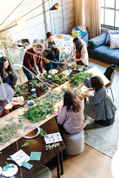 women crafting with greenery at workshop table