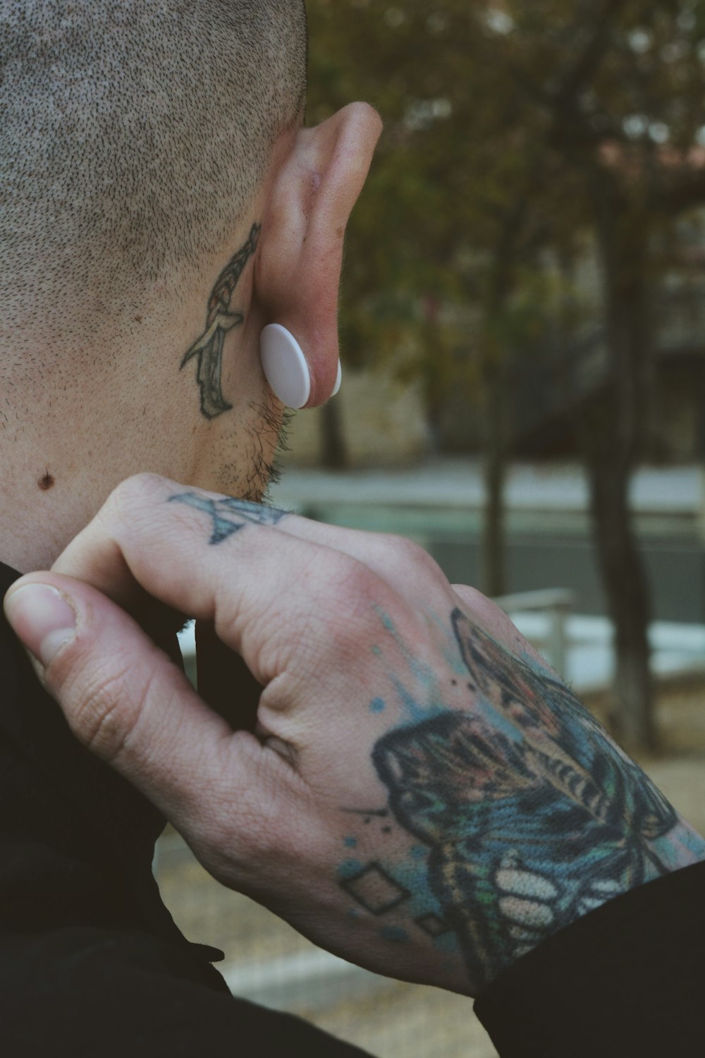 back shot photography of man looking at trees while touching his clothes collar